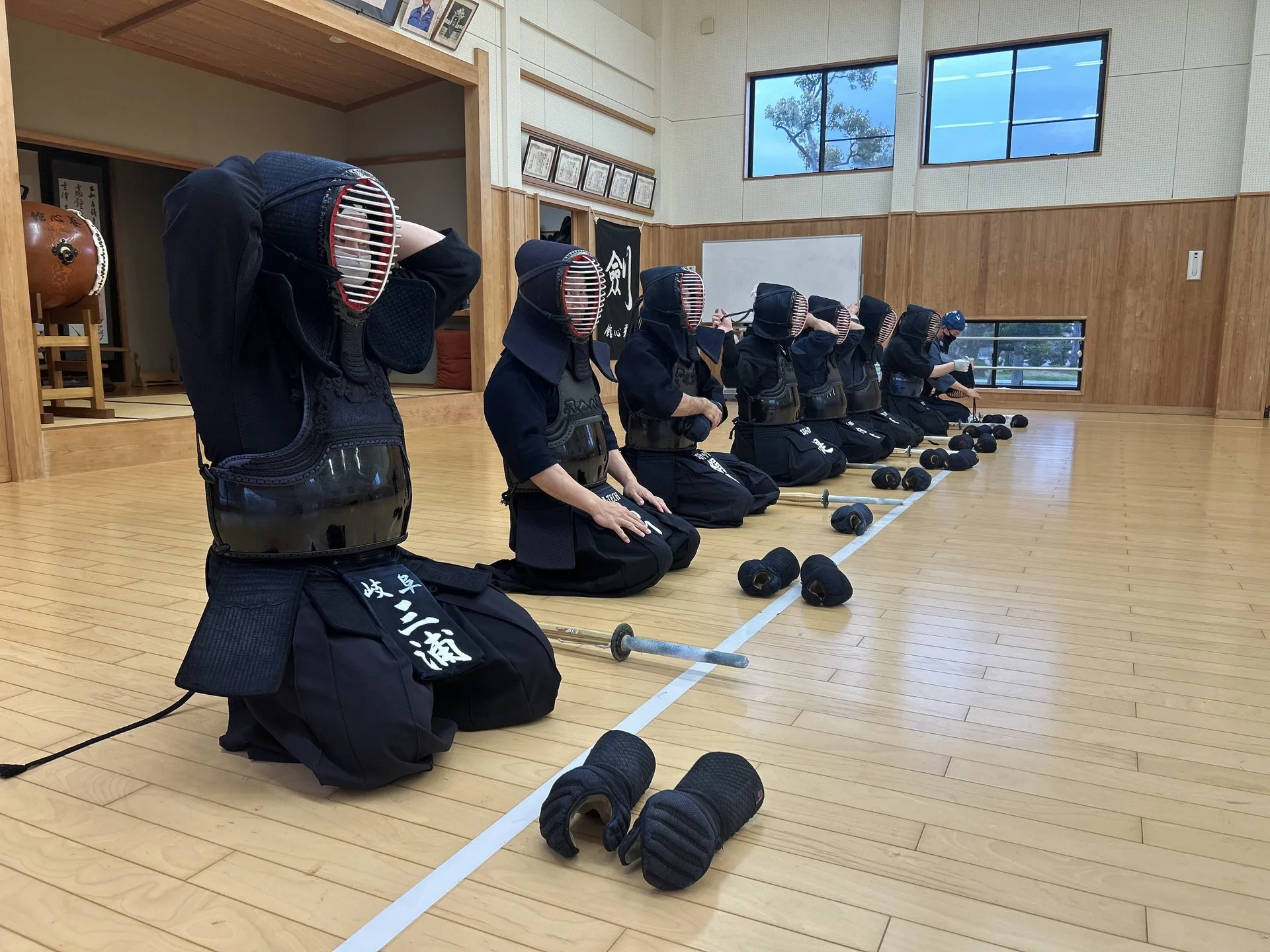 STAGE 05 整列 — 三浦俊彦らエヌテック剣道部員16名が整列、面紐を結ぶ集団の風景